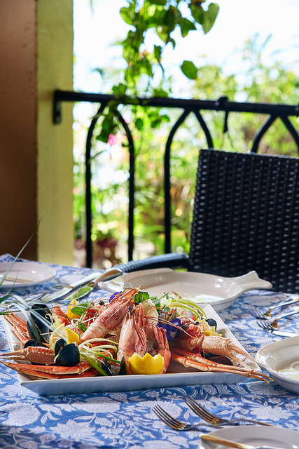 a plate of seafood on a table with a view of the ocean